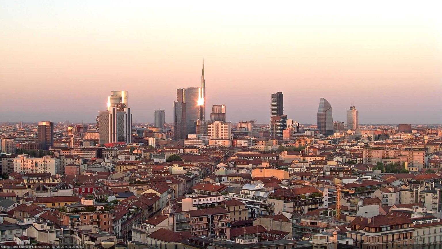 Veduta dei palazzi di Milano al tramonto, simbolo del mercato degli affitti brevi in Italia.